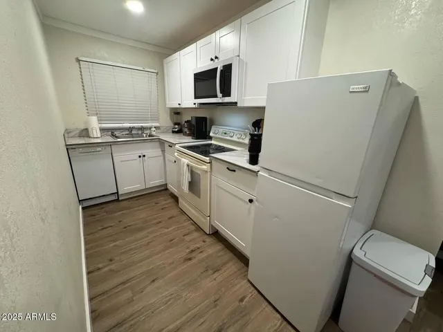 a kitchen with a sink a refrigerator a microwave and cabinets