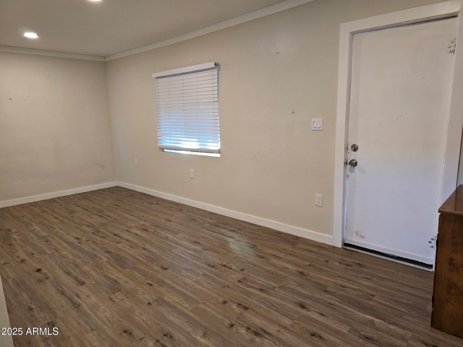 19 West Fremont Street, Unit 4 Tombstone, AZ 85638 - Photo 8 of 14 a view of an empty room with wooden floor and a window