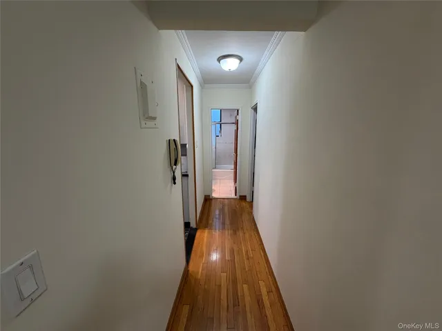 a view of a hallway with wooden floor and closet