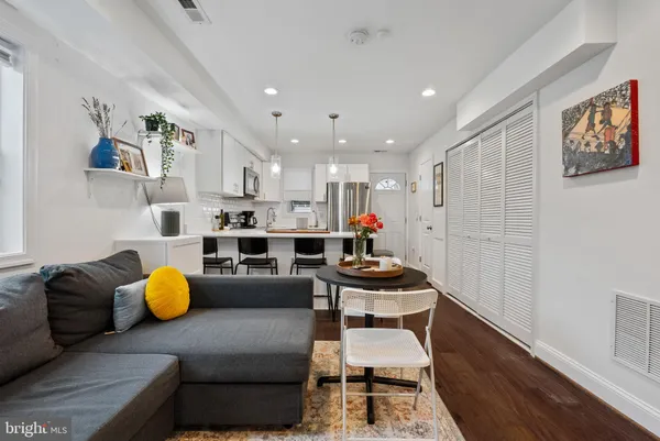 a living room with furniture and kitchen view