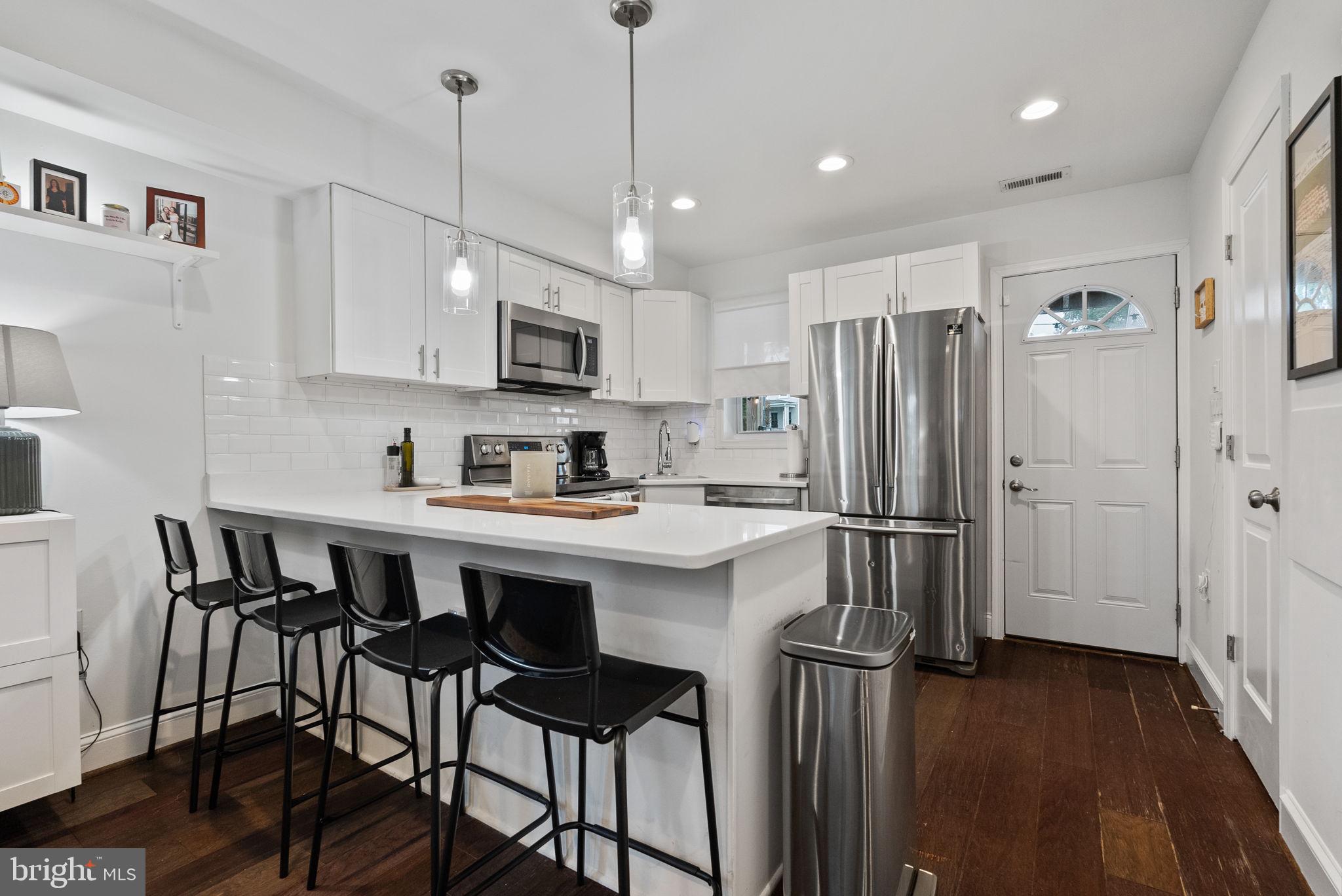 2000 East A Street Northeast Washington, DC 20002 - Photo 9 of 26 a kitchen with stainless steel appliances granite countertop a refrigerator a sink dishwasher a stove and white cabinets with wooden floor