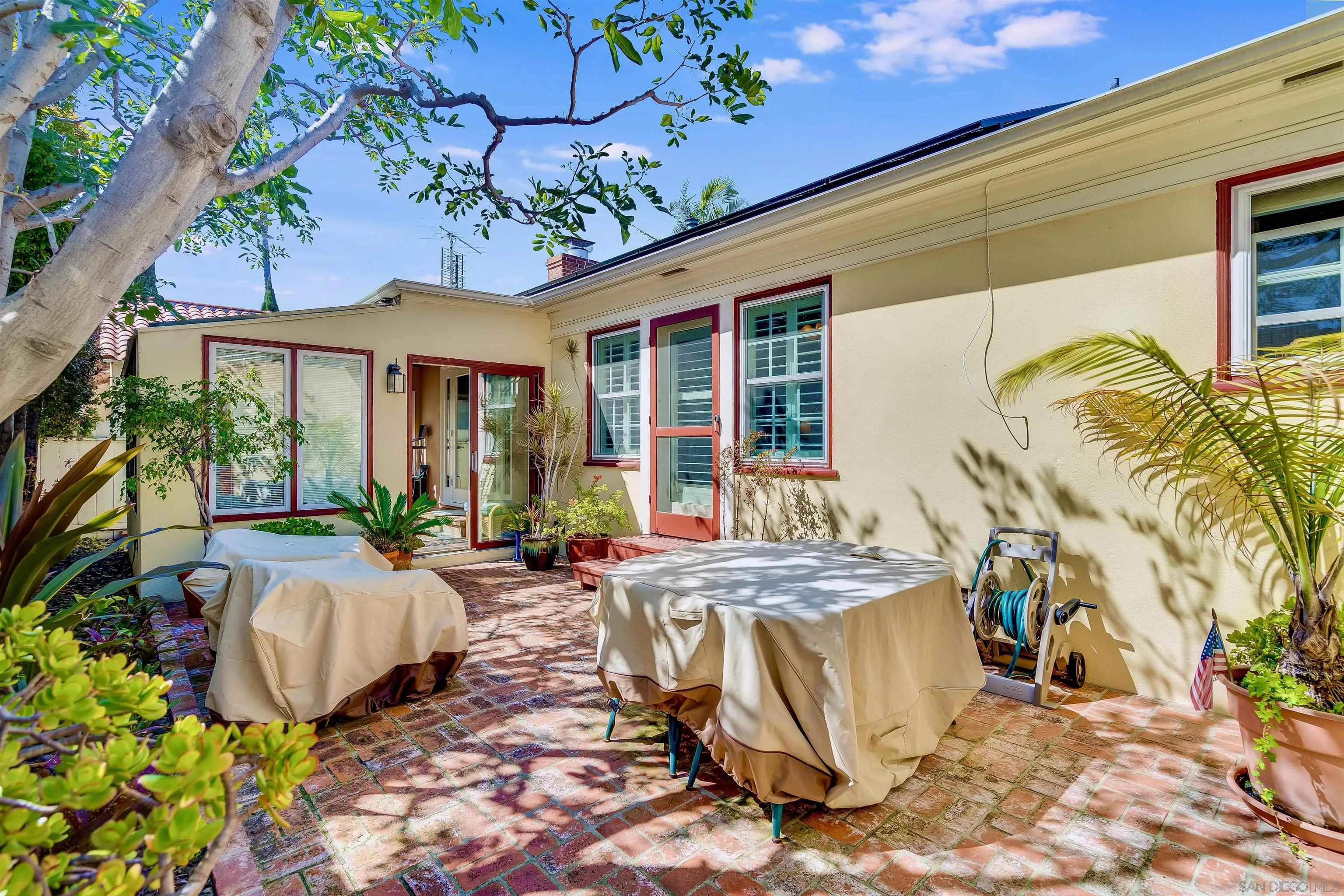 1210 Third Street Coronado, CA 92118 - Photo 26 of 40 a view of a patio with table and chairs potted plants and a large tree