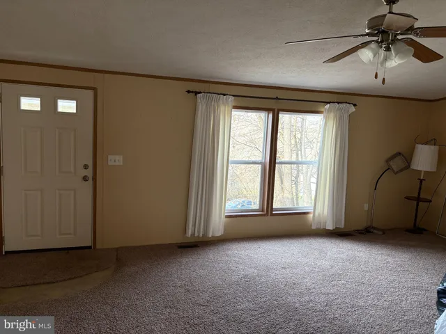 an empty room with a ceiling fan and a window