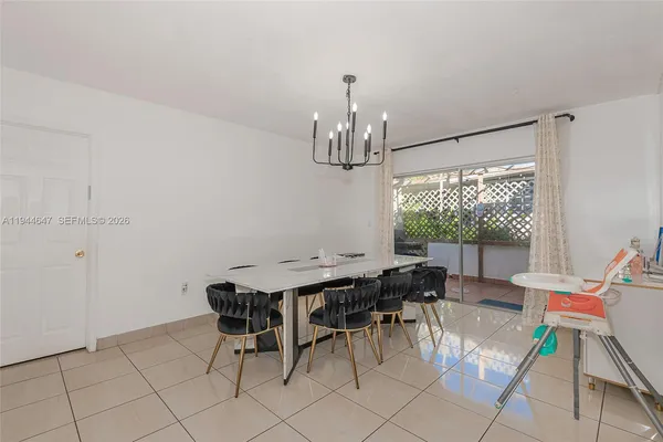 a view of a dining room with furniture a chandelier and wooden floor