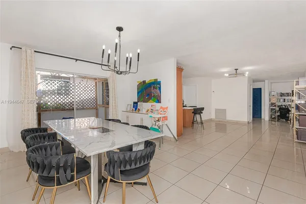 a dining room with furniture a chandelier and wooden floor