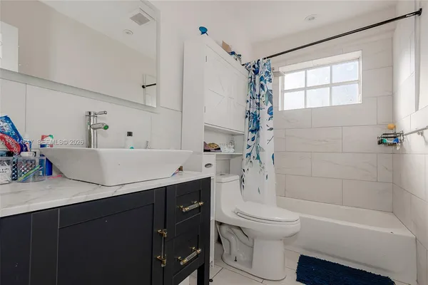 a bathroom with a sink toilet vanity and bathtub