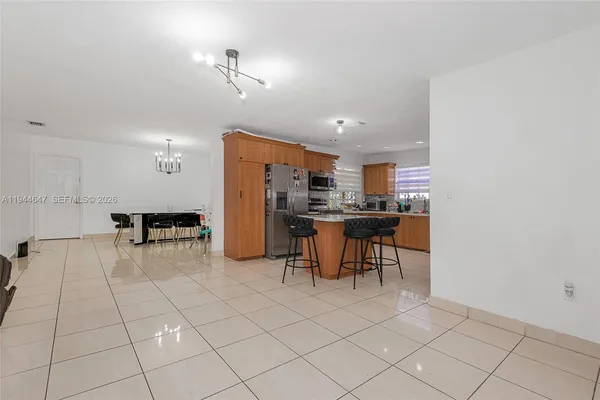 a kitchen with stainless steel appliances kitchen island granite countertop a refrigerator and a stove top oven