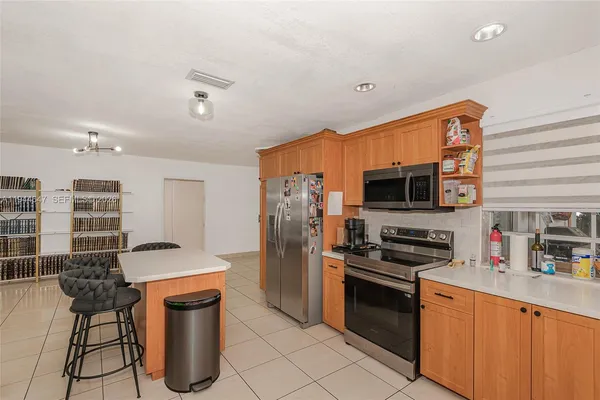 a kitchen with stainless steel appliances a stove a sink a microwave a refrigerator and cabinets