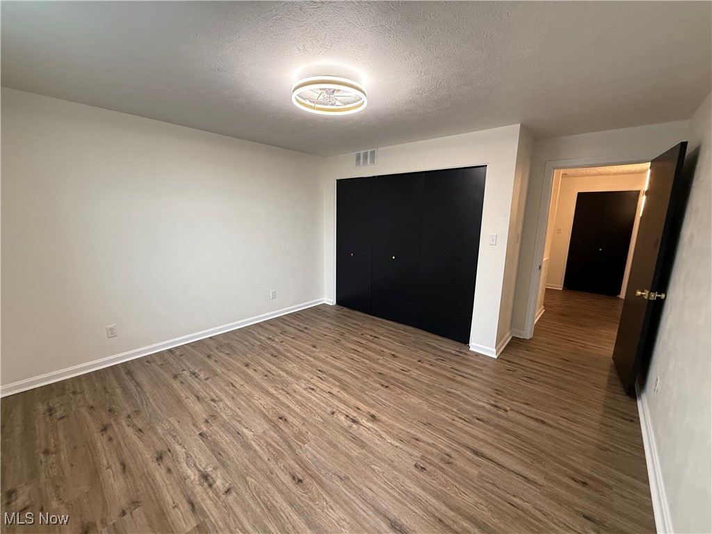 522 North 3rd Street Toronto, OH 43964 - Photo 32 of 47 Unfurnished bedroom with a textured ceiling, wood finished floors, and a closet