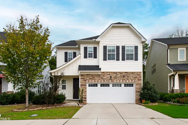 a front view of a house with a yard and trees