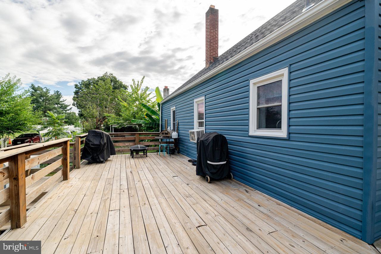 257 Center Street Timberville, VA 22853 - Photo 50 of 73 a view of a roof deck with table and chairs a barbeque with wooden floor and fence