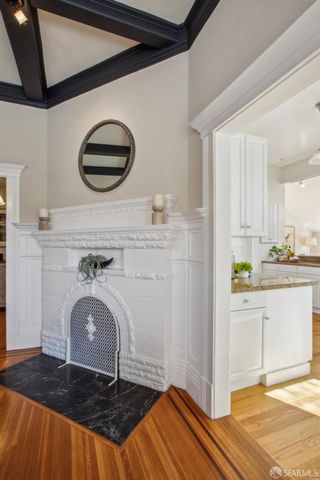 a kitchen with stainless steel appliances granite countertop a stove a refrigerator a dining table and chairs with wooden floor