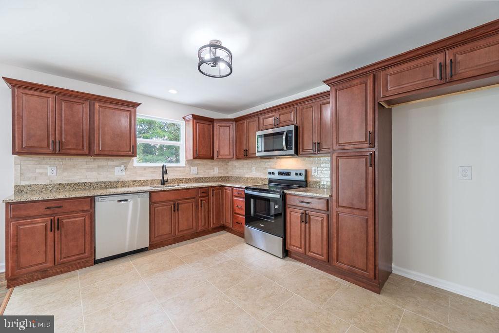 231 East Avon Road Brookhaven, PA 19015 - Photo 14 of 33 a kitchen with stainless steel appliances granite countertop a refrigerator stove top oven a sink and dishwasher