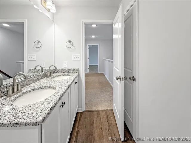 a bathroom with a granite countertop sink a mirror and shower