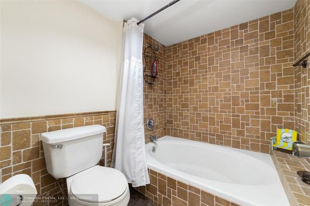 a white toilet sitting next to a bath tub