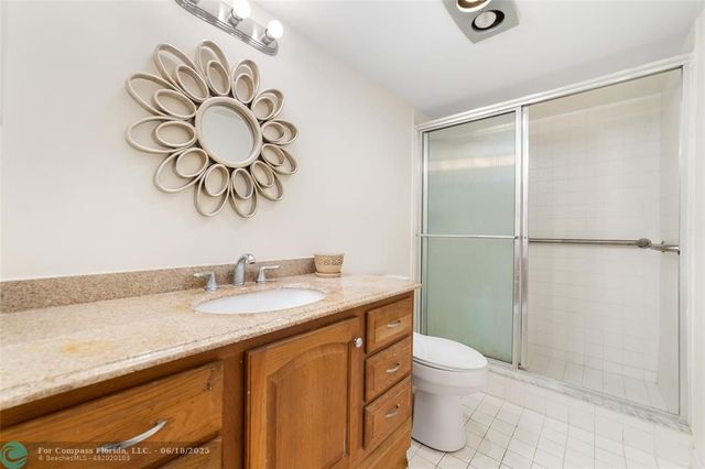 a bathroom with a granite countertop sink a toilet and a mirror