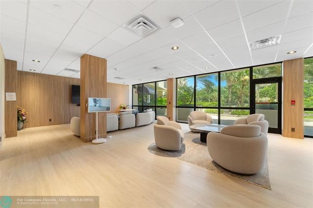 a living room with furniture and large windows