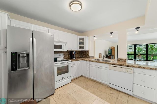 a kitchen with stainless steel appliances granite countertop a refrigerator and a sink