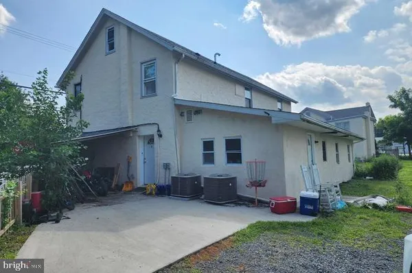 a backyard of a house with table and chairs a barbeque