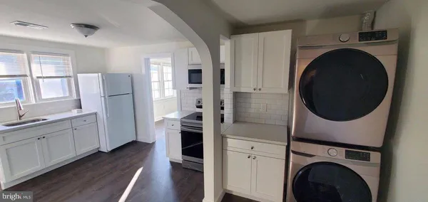 a view of a kitchen with refrigerator and wooden floor