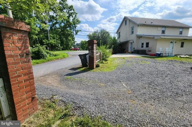 a view of a house with a yard and a large tree
