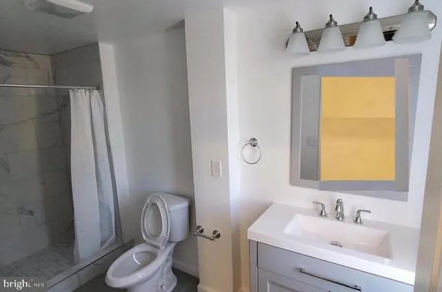 a bathroom with a toilet sink vanity and mirror