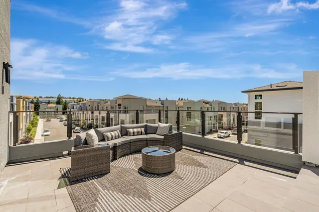 a view of a terrace with couches and sky view