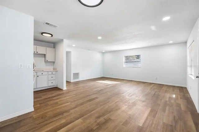 a view of empty room with wooden floor
