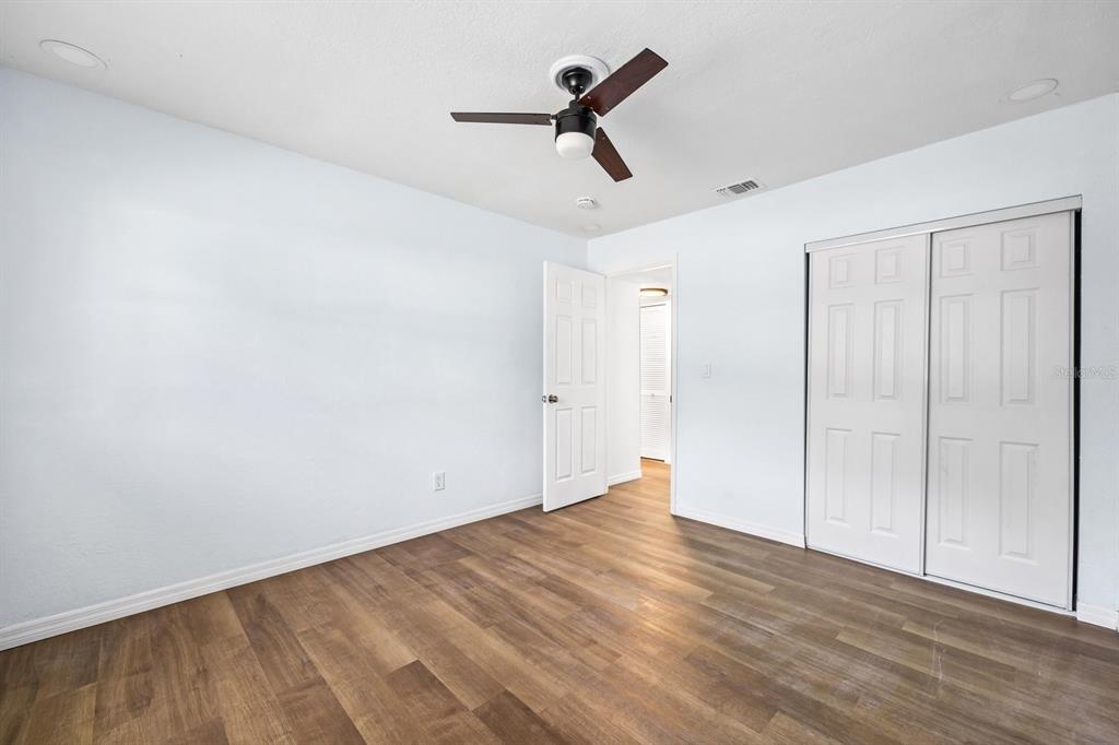 1132 Auburn Street Clearwater, FL 33756 - Photo 7 of 9 a view of empty room with wooden floor and ceiling fan