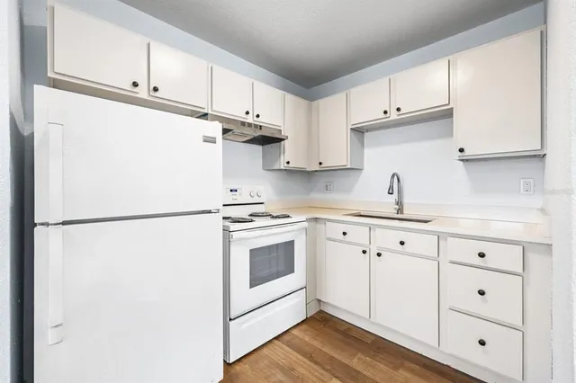 a kitchen with cabinets appliances a sink and a center island