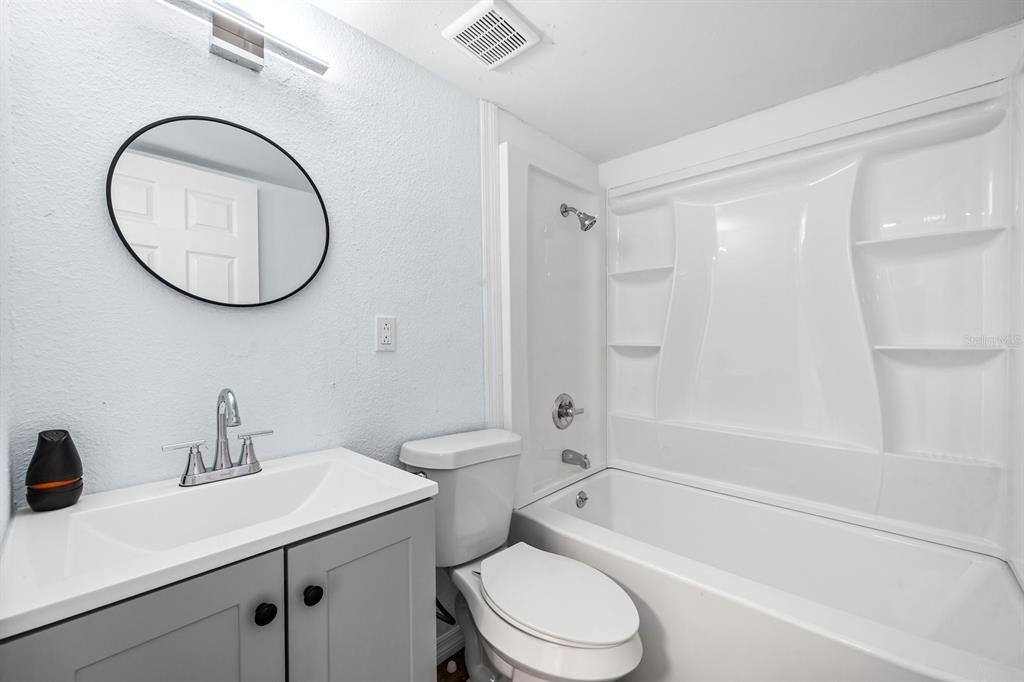 1132 Auburn Street Clearwater, FL 33756 - Photo 9 of 9 a bathroom with a sink a toilet and a mirror