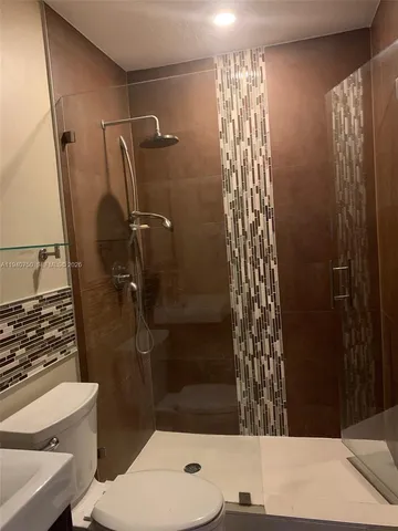 a bathroom with a shower toilet and sink