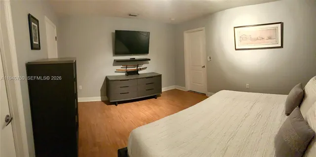 a bedroom with a bed and flat screen tv