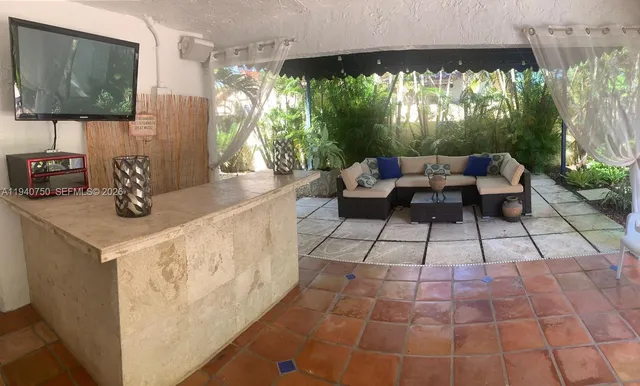 a living room with a rug floor to ceiling window and a flat screen tv