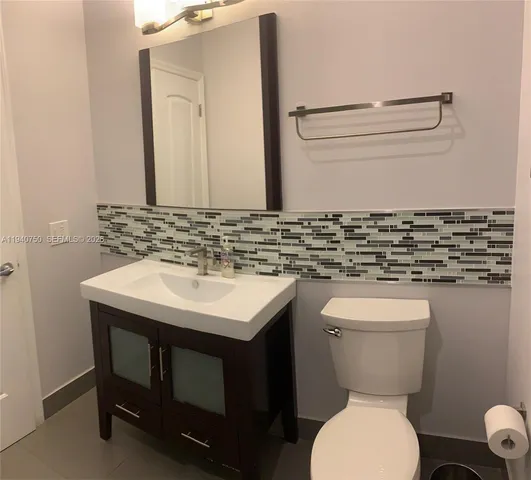 a bathroom with a sink a toilet and mirror