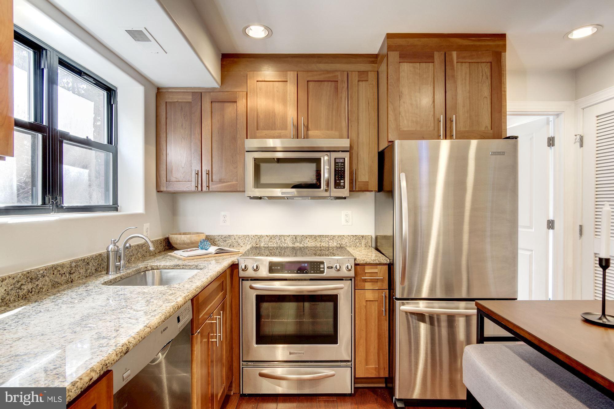 1354 Euclid Street Northwest, Unit 201B Washington, DC 20009 - Photo 12 of 30 Light Cherry cabinets, granite, & stainless steel