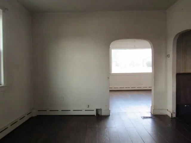 a view of a room with wooden floor and a window