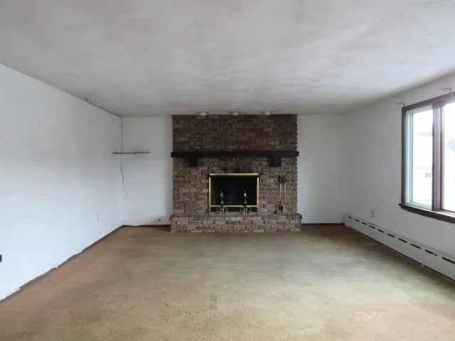 an empty room with a fireplace and window