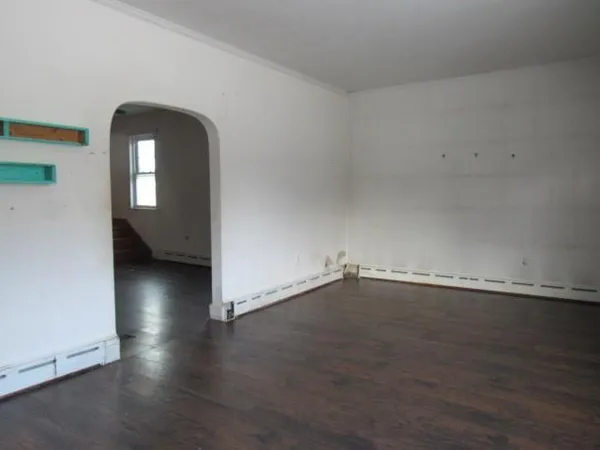 an empty room with wooden floor and a window