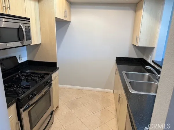 a kitchen with granite countertop a stove and a microwave