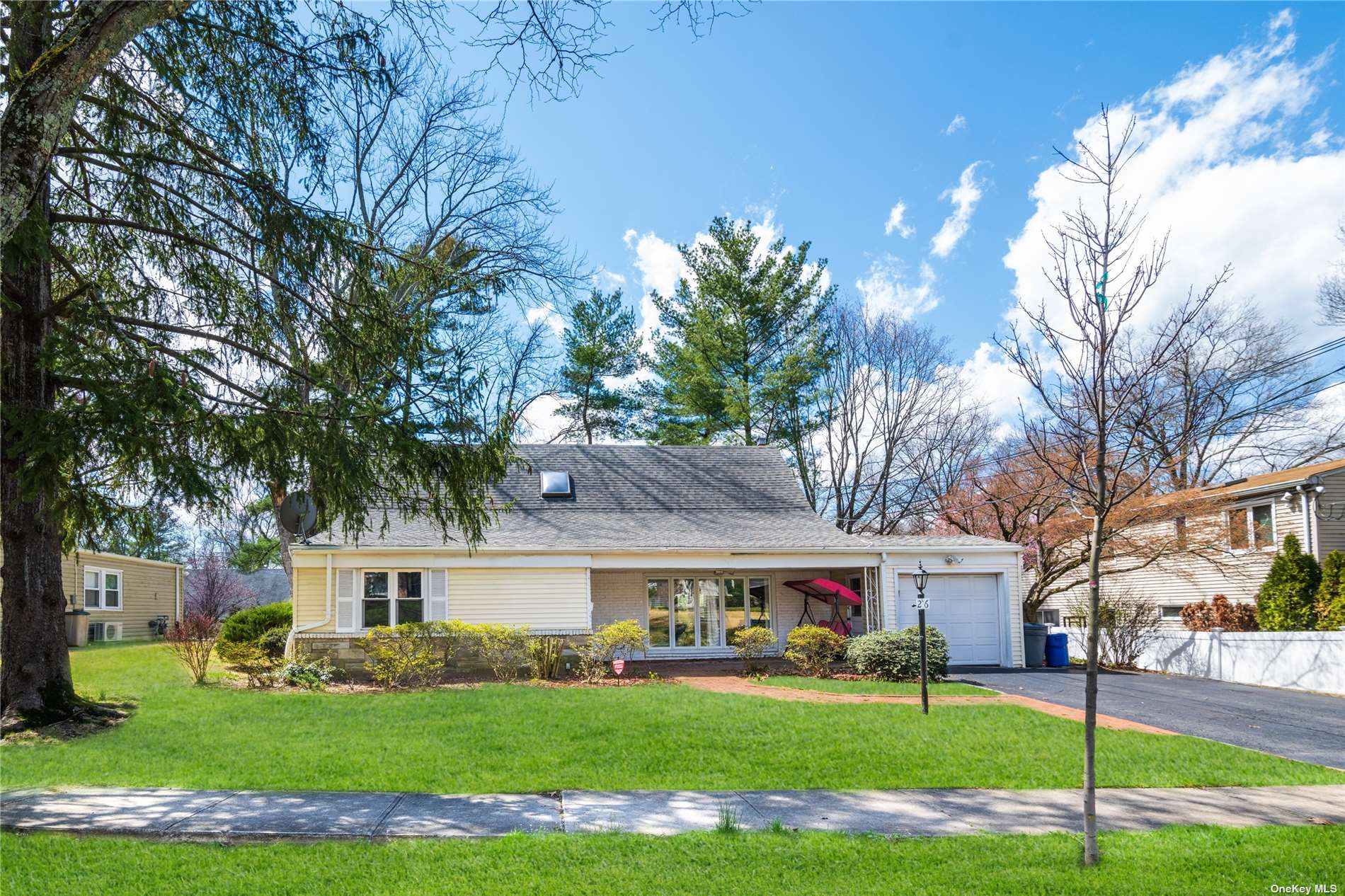 26 Duxbury Road Great Neck, NY 11023 - Photo 1 of 1 a front view of a house with garden and trees