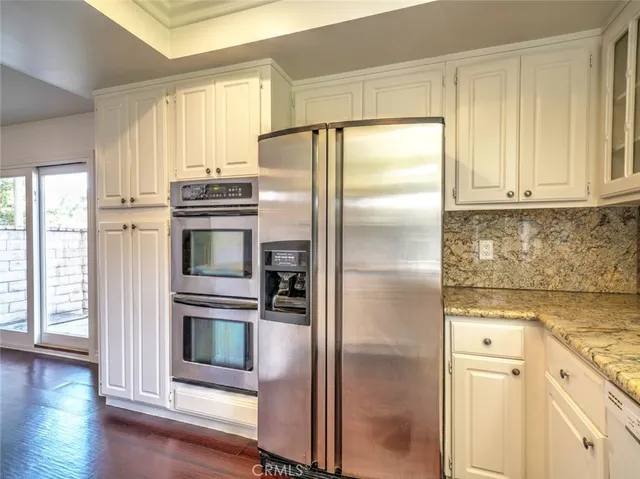 a kitchen with stainless steel appliances granite countertop a refrigerator and a stove top oven