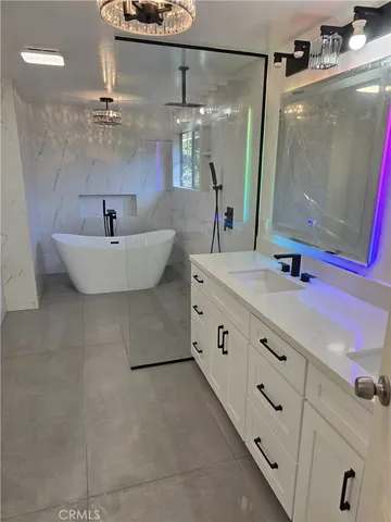 a bathroom with a double vanity sink mirror and bathtub