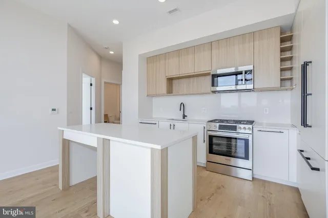 a kitchen with stainless steel appliances a sink stove and cabinets