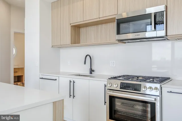 a kitchen with stainless steel appliances granite countertop white cabinets and stove