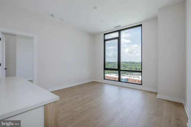 a view of a room that has wooden floor and cabinets in it