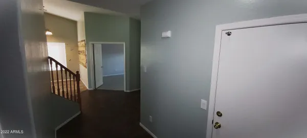 a view of a hallway with wooden floor and closet