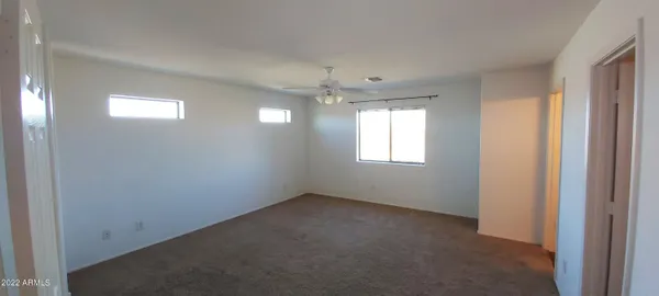 en empty room with windows and fan