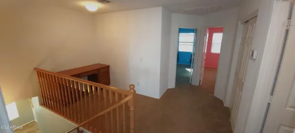 a view of a hallway with a chandelier fan and windows