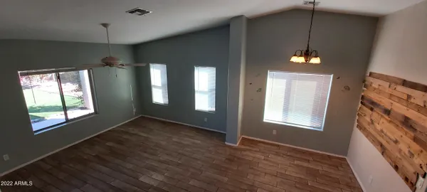 a view of an empty room with a window and wooden floor